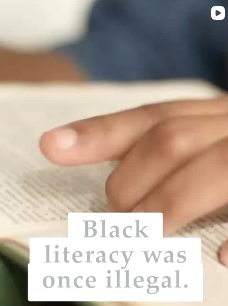 Black literacy was once illegal - hand pointing at book